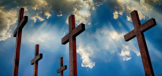 Wooden crosses against a dramatic cloud-filled sky with rays of sunlight, symbolizing faith, hope, and Christian spirituality.
