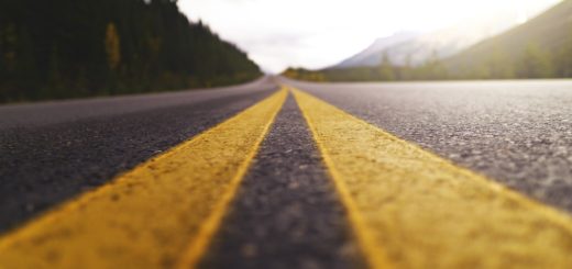 Open road with yellow lane markings, scenic mountain landscape, highway travel, adventure, journey, road trip, nature, outdoors, travel destination.