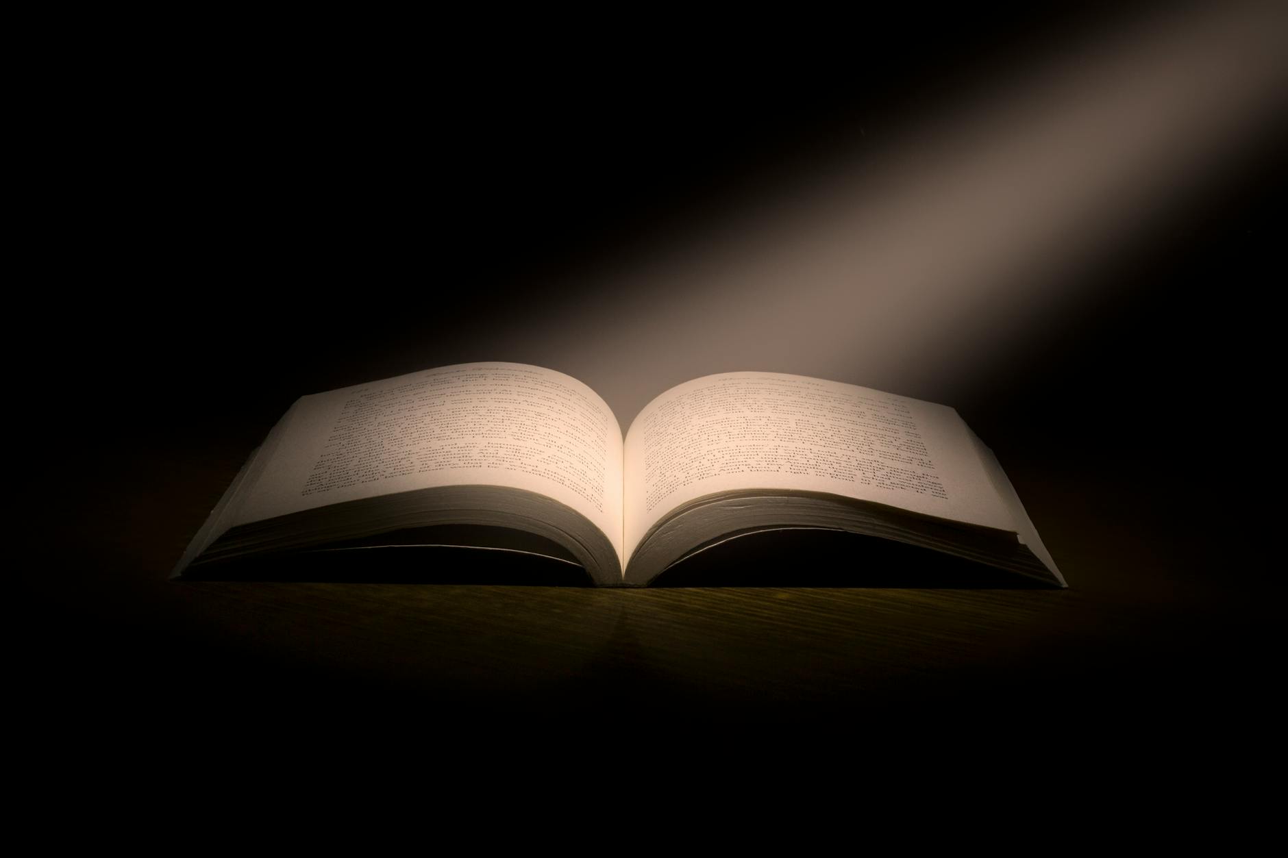 Open Bible illuminated with light, symbolizing faith and spirituality, used in Christian worship, prayer, and Bible study.